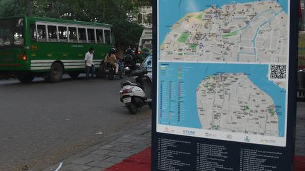 A Kochi Ithile wayfinding sign beside a road in Fort Kochi, with maps of Fort Kochi and Mattancherry, a QR code, and a numbered list of places